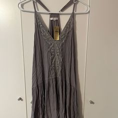 This Dress Is From American Eagle And It Is Listed As Being One Size, Which Means That It Will Fit If You Are An Xs-Xl. This Dress Is Purple And It Has Lace That Goes Down The Center Of The Dress. This Dress Is Oversized And It’s Perfect To Throw Over A Bathing Suit And Go To The Beach In! It’s Stylish And Still Very Functional. The Straps Are Adjustable Depending On What Size You Are. This Dress Is Brand New With The Original Tags Still Attached And It’s In Excellent Condition As It’s Never Bee Sleeveless Gray Vacation Dress, Gray Sleeveless Vacation Dress, Gray Sleeveless Dress For Vacation, Gray Sleeveless Sundress, Gray Sleeveless Tank Top For The Beach, Gray Sleeveless Tank Top For Beach, Spring Vacation Tank Dress, Gray Sleeveless Spring Dress, Gray Spaghetti Strap Spring Dress