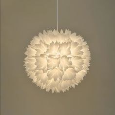 a white flower shaped light hanging from a ceiling