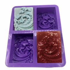 four different colored ice trays with designs on them