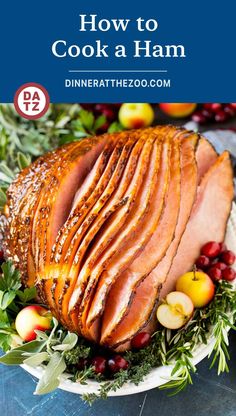 ham on a platter with apples and cranberries in the background text reads how to cook a ham