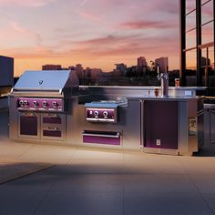 an outdoor bbq grill with purple lighting on the side and buildings in the background