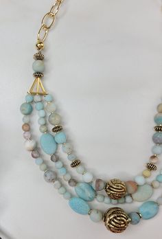 Our Blue Echo necklace is a three strand beauty, each strand an echo of the previous. It was carefully handcrafted with blue amazonite stone beads and contrasting gold vintage beads. The three strands are joined with an unusual and interesting triangular element. This necklace is completed with gold plated cable chain. As a gift for the beauty in your life or for yourself, this glamorous piece is perfect. A matching bracelet and earring set are available. Features: - Vintage Elements - Gold Plat Multi-strand Turquoise Gemstone Beads Necklace, Multi-strand Turquoise Gemstone Beads Necklace For Jewelry Making, Multi-strand Turquoise Necklace For Jewelry Making, Unique Amazonite Jewelry With Round Beads, Chain Ideas, Bracelet And Earring Set, Stolen Heart, Amazonite Necklace, Vintage Elements