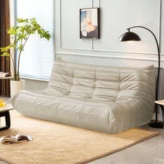 a living room with a futon couch and coffee table in the corner next to a window