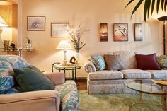 a living room with couches, chairs and tables in it's center area