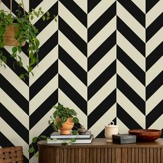 black and white striped wallpaper with potted plant next to it on a table