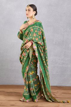 Emerald green saree blouse with all-over floral motifs, cutwork detail, tassel tie-ups and plunging neck.
Component: 1
Printed
Neckline: V Neck
Sleeve Length: Long
Fabric: Handwoven Chanderi, cotton silk
Color: Green
Plunging neck
Cutwork detail
Cuff sleeves
Note: Saree worn by the model is not for sale
 - Aza Fashions Green Bollywood Blouse With Chikankari Embroidery, Festive Green Chikankari Embroidery Blouse Piece, Festive Green Blouse With Chikankari Embroidery, Green Cotton Silk Blouse With Dupatta, Spring Green Saree With Floral Print, Spring Green Floral Print Saree, Bohemian Green Set With Unstitched Blouse, Unstitched Green Saree Blouse, Green Cotton Silk Saree Blouse