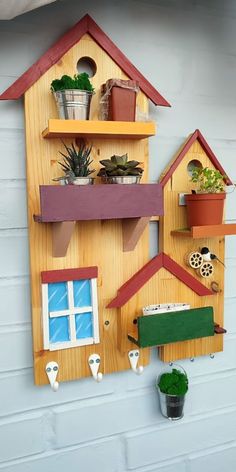 a wooden house shaped shelf with potted plants on it