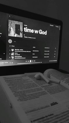 an open book sitting in front of a computer monitor with the word time w god on it