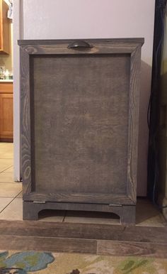 a wooden cabinet sitting on top of a tile floor next to a door and rug