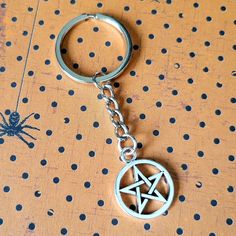 a metal keychain with a pentagramil on it sitting on top of a table