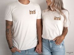 a man and woman standing next to each other wearing shirts with the word dad on them