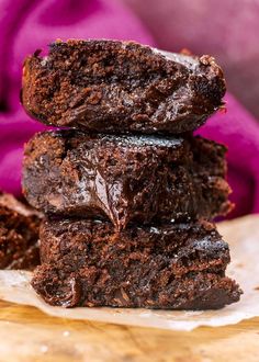 three chocolate brownies stacked on top of each other with one bite taken out of it