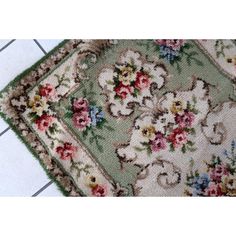 two rugs sitting on top of a tile floor next to each other with flowers