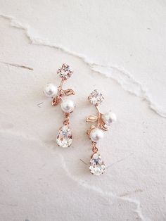 "These delicate vintage inspired earrings are made with fine Swarovski crystals and Swarovski pearls. Available in gold, silver or rose gold finish and with white or ivory pearl. Shown in the photos in rose gold finish with white pearls. - Measurements: 1 1/2\" long and 1/2\" wide at the wides point - Post earrings with butterfly ear-nuts" Rose Gold Pearl Drop Flower Earrings For Wedding, Rose Gold Flower Earrings With Pearl Drop For Wedding, Rose Gold Pearl Drop Flower Earrings, Rose Gold Flower Drop Earrings With Pearl, Elegant Rose Gold Bridal Earrings, Rose Gold Pearl Bridal Earrings For Anniversary, Elegant Rose Gold Drop Bridal Earrings, Elegant Rose Gold Bridal Drop Earrings, Anniversary Rose Gold Pearl Bridal Earrings