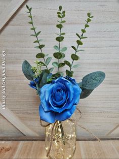 a blue rose sits in a glass vase