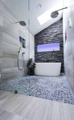 a bathroom with a large white tub sitting next to a walk in shower under a skylight