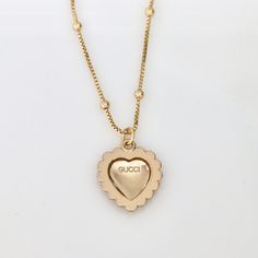 Stunning authentic Gucci heart-shaped pendant with classic interlocking GG logo in light champagne gold tone with elegant faux pearl detail. Product details: necklace length: 17.9 inches necklace material: 18k gold plated satellite chain pendant measurements: 20mm pendant is stamped "GUCCI" for authenticity Gold-tone Logo Plaque Pendant Necklace, Elegant Gold Plated Jewelry With Logo Charm, Elegant Gold Jewelry With Logo Charm, Designer Gold Necklaces For Anniversary, Luxury Gold-tone Logo Plaque Pendant Jewelry, Elegant Gold-tone Necklace With Logo Charm, Luxury Pendant Jewelry With Gold-tone Logo Plaque, Elegant Yellow Gold Necklace With Logo Charm, Luxury Gift Necklace With Gold-tone Logo Plaque