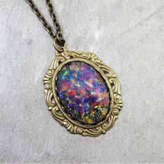 "This lovely pendant features a vintage man made black opal glass cabochon. *These are not real opals. They are rare vintage man-made glass jewels. They are absolutely STUNNING with a myriad of vivid colors on a jet black glass base along with electric blue flashes. I am always searching for rare and unique vintage glass jewels and these were a wonderful find! They are some of the most incredible glass jewels that I have ever seen. Due to their handmade nature, no two are exactly alike...each is Opal Necklace Pendant, Black Opal Necklace, 33 Birthday, Black Fire Opal, Vintage Man, Opal Pendant Necklace, Black Fire, Brass Pendant, Opal Pendants