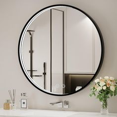 a bathroom with a sink, mirror and flowers on the counter top in front of it