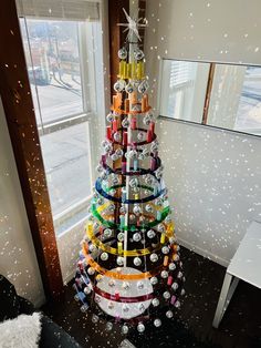 a christmas tree made out of cans in front of a window