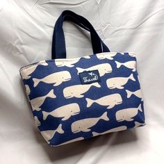 Lunch By The Sea Insulated Bag Have A Whale Of A Time Bringing Your Lunch In This Cute Insulated Bag. Canvass Type Fabric With Familar Whale Print Size 13 X 8 X 4.5 Approximate Light Weight And Easy To Pack Handle Drop 5 Inches Blue Satchel Canvas Bag For Summer, Beige Large Capacity Lunch Bag For Daily Use, Blue Large Capacity Bucket Canvas Bag, Large Capacity Blue Lunch Bag For School, Casual White Lunch Bag For Travel, Casual White Lunch Bag For Daily Use, Casual Beige Lunch Bag For Daily Use, Blue Tote Lunch Bag For Travel, Large Capacity Beige Lunch Bag For Everyday