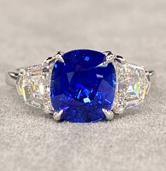 a blue and white stone ring with three diamonds