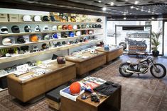 a motorcycle is on display in a room with lots of hats and other items around it