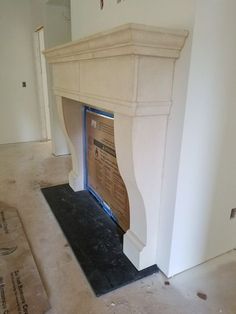 an unfinished fireplace in the middle of a room with no one around it and some boxes on the floor