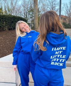 two women in matching blue tracksuits standing next to each other