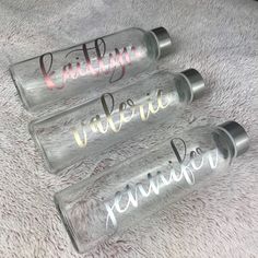 three personalized water bottles sitting on top of a bed