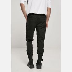 These men's pants combine functionality with superior military style. The cotton twill material is robust and uncomplicated. The fit of the jogger is regular. It has two patch cargo pockets with flap and metal push button on the thighs as well as side pockets and back pockets. The elastic waistband with its knotted drawstring ensures the finest wearing comfort. The leg ends can also be adjusted via a Velcro closure. Adding even more structure to these functional men's pants is the cross-division Jog Pants, Urban Apparel, Tactical Jacket, Outerwear Vest, Jogging Pants, Men's Pants, Military Style, Sweatshirt Shirt, Urban Outfits