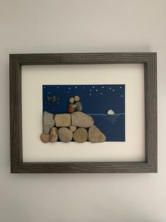 there is a painting on the wall that has rocks in front of it and a teddy bear sitting on top