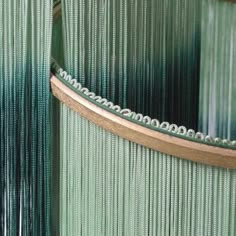 a close up view of a curtain with beads on the bottom and sides, hanging from a metal rod