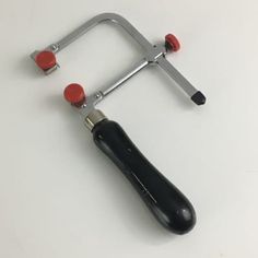 a black and red tool sitting on top of a white table