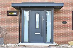 the front door of a brick building with glass panels and sidelights on either side