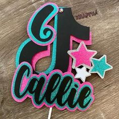 a birthday cake topper with the number one on it and stars in pink, blue and black