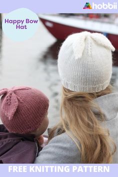 a woman and child wearing knitted hats looking at boats in the water with text overlay that reads happy bow hat free knitting pattern