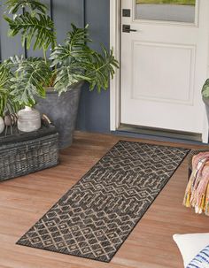 a door mat on the front porch with potted plants