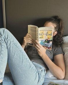 a woman laying in bed reading a book