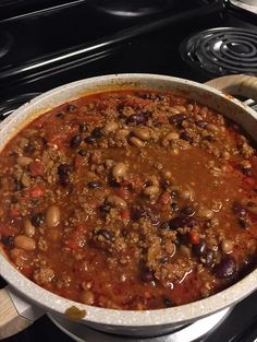 a large pot filled with chili and beans on top of a stove