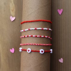 the bracelets have hearts on them and beads in red, white, and pink