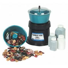 a blue and black grinder with three bottles next to it