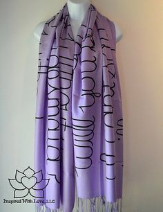 a purple scarf with black writing on it and a white mannequin behind it