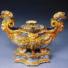 an ornately decorated teapot with gold and blue decorations