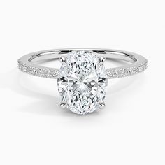 an oval cut diamond ring with pave set shoulders