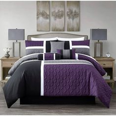 a bed with purple and black comforters in a bedroom next to two nightstands