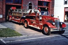 an old fire truck parked in front of a building