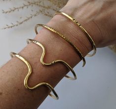 "Another versatile classic, handcrafted from raw brass.  Wear one alone for a minimalist touch, or stack them up for a bolder bohemian look. Choose from 4 styles of cuff, or make it a set of 4 Find your perfect fit: All cuffs are adjustable, but ordering the correct size will ensure your most comfortable fit. Measure the circumference of your wrist by wrapping a flexible tape measure around the wrist just below the wrist bone, making note of where the tape overlaps.  Use the chart below to determine your size: S - 5 - 6\" M - 6 - 6.5\" L - 6.5 - 7\" XL - 7 - 8\" For a looser bangle-style bracelet consider sizing up one or two sizes. Please note that because each piece is handmade to order, yours may differ slightly from the ones pictured above but will of course stay true to them in essenc Bangles Style, Bohemian Look, Metal Pendant, Opal Jewelry, Tape Measure, Raw Brass, Infinity Bracelet, Delicate Bracelet, One Pic