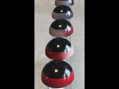 four balls are lined up in a row on a table top with one red and the other black