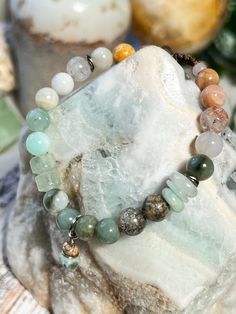 This simple, yet elegant blissful bracelet is refreshing and relaxing with natural greens (jade, aquamarine, lodolite), whites (moonstone, jade, lodolite), and orange (sunstone, jade, lodolite) . Featuring different shaped stones in jade and aquamarine, and accented with a handmade charm in tree agate and ocean jasper, on a durable, adjustable nylon cord. Everyday Spiritual Aventurine Bracelets, Bohemian Aventurine Bracelets For Healing, Bohemian Aventurine Gemstone Beads Bracelets, Bohemian Jade Crystal Bracelet For Healing, Bohemian Aventurine Bracelet With Natural Stones, Spiritual Moss Agate Beaded Bracelets With Natural Stones, Earthy Natural Stones Bracelet For Healing, Holistic Aventurine Bracelets With Natural Stones, Bohemian Aventurine Gemstone Bracelets